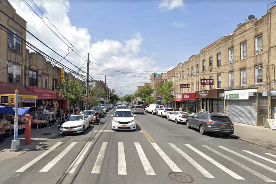 Google Street View of 8th Avenue in Brooklyn with crosswalk in foreground, cars, and brick three-story buildings